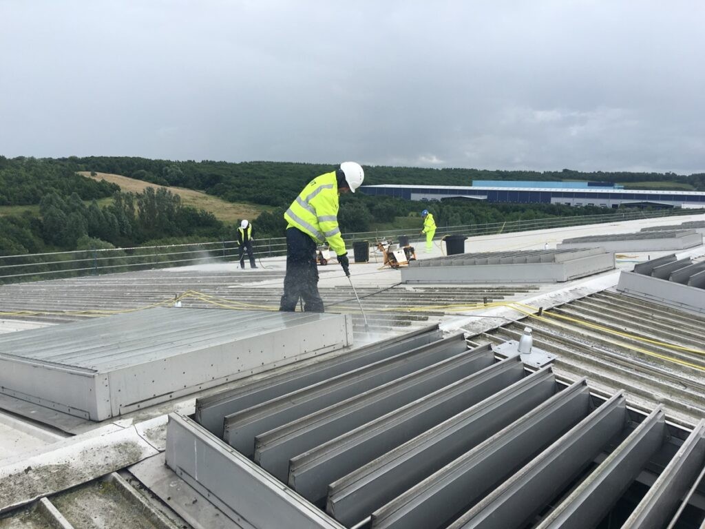 Crew applying roof coating on top of a commercial roof in Meadville, PA.